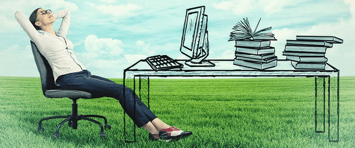 stock photo of woman sitting at drawn desk in grass