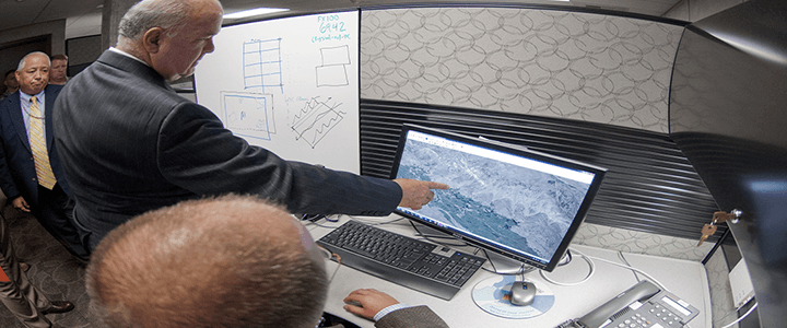 man pointing at map on computer screen