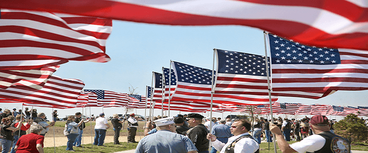 people holding American flags on flag day