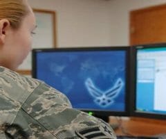 soldier sitting at computer monitors