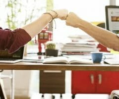 two male colleagues fist bumping