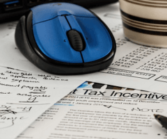 stock photo of computer mouse on tax paperwork