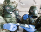 men in uniform with gas masks measuring for chemical weapons