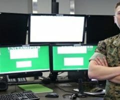 marine standing in front of computer screens