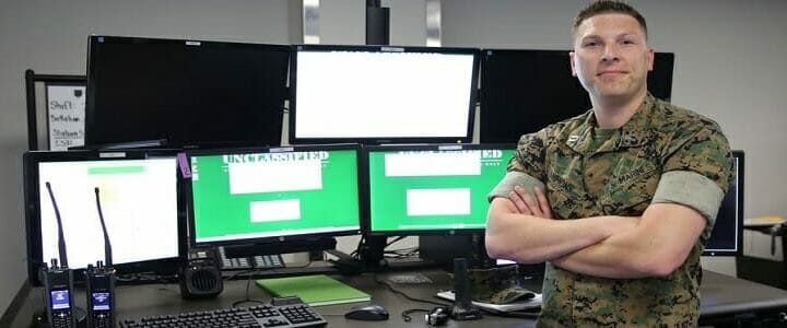 marine standing in front of computer screens