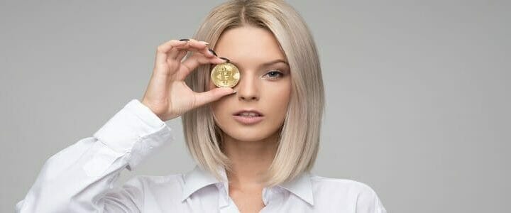 stock photo of woman holding bitcoin over eye