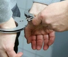 stock photo of handcuffs being put on man