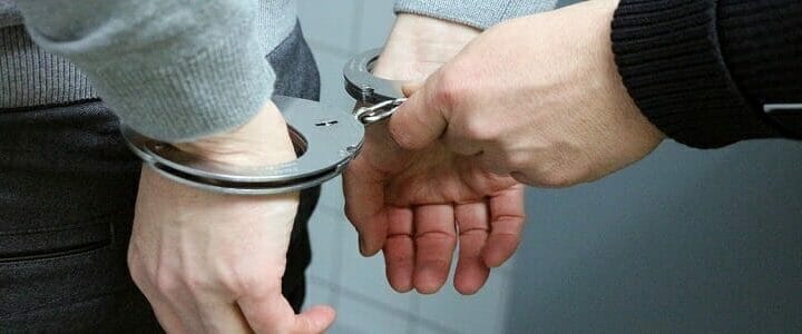 stock photo of handcuffs being put on man