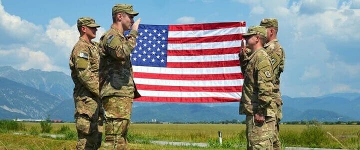 soldiers in uniform in field with american flag
