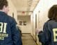two fbi agents walk down hallway at washington field office