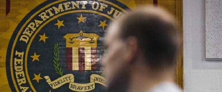 FBI seal on wall behind blurred man