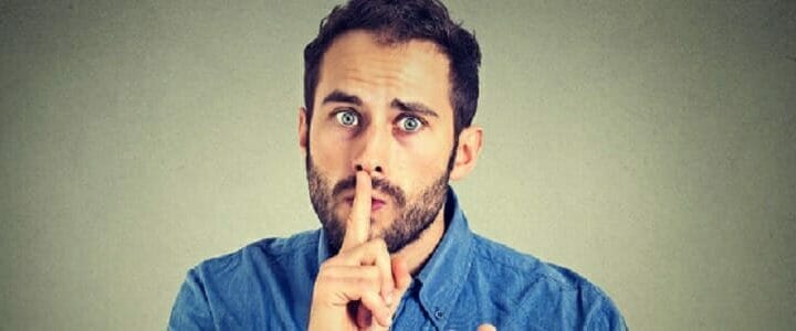 stock photo of man with finger to mouth saying shh