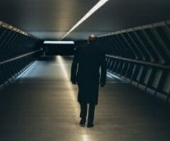 Man walking down long dark hallway