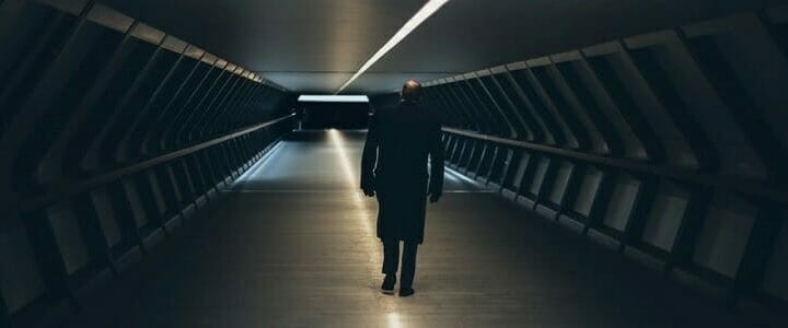 Man walking down long dark hallway