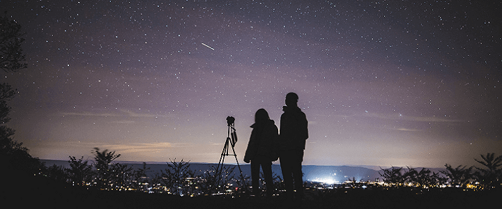 stock photo of people looking at stars over city