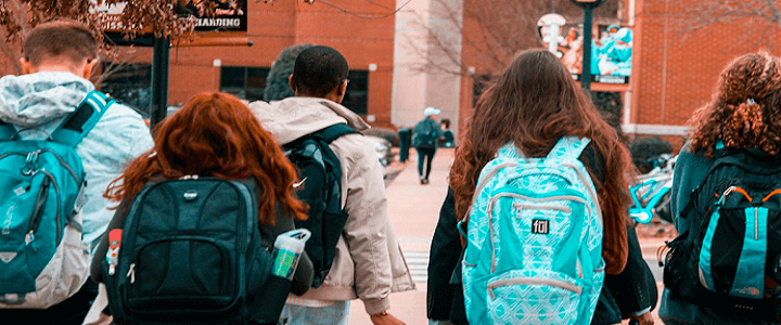 stock photo of college students with teal backpacks on campus