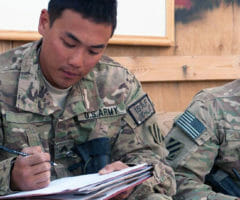 Men in uniform filling out paperwork