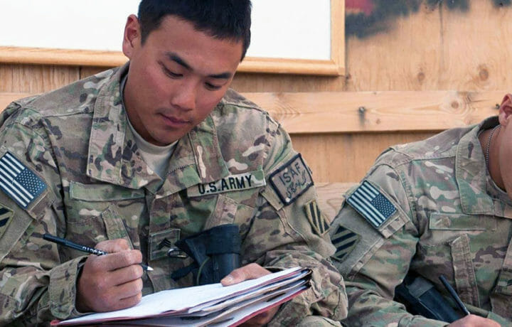 Men in uniform filling out paperwork