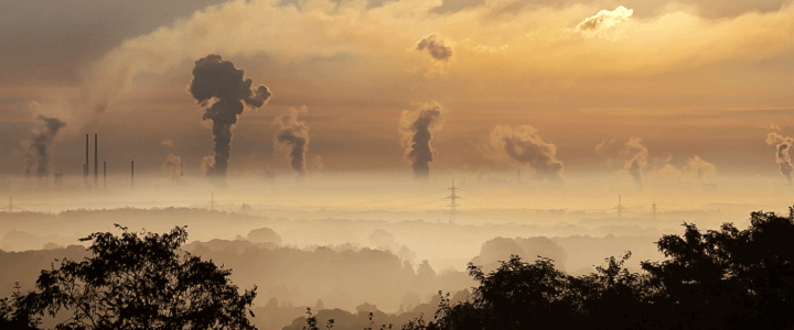 Photo of smokestacks and smoke on horizon at dawn