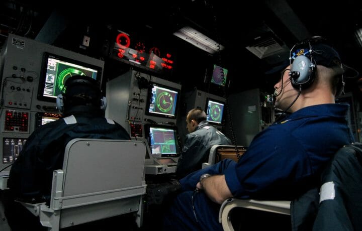 Military personnel in command room of surface ship