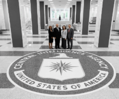 Man and three women standing on seal at CIA