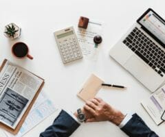 Stock photo of man at desk with computer and accounting paperwork