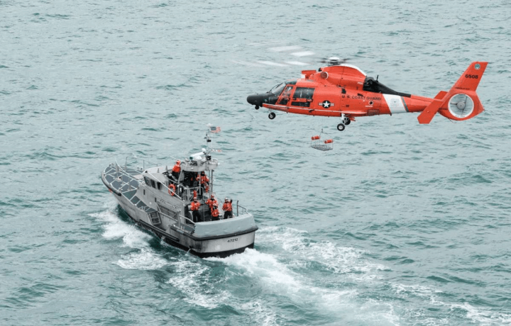 US Coast Guard helicopter flying over Coast Guard ship