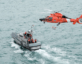 US Coast Guard helicopter flying over Coast Guard ship