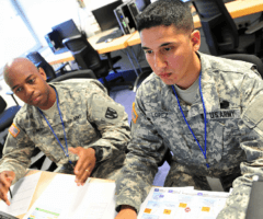 Men in uniform looking at computer screen