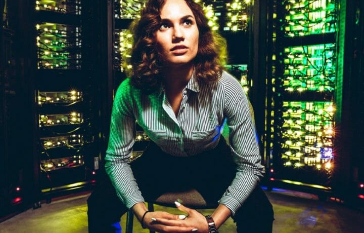Woman leaning forward on chair with server racks in background