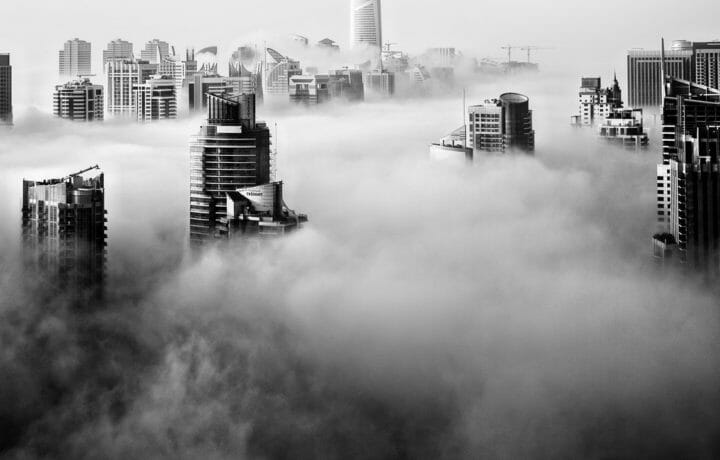City buildings poking up out of low fog