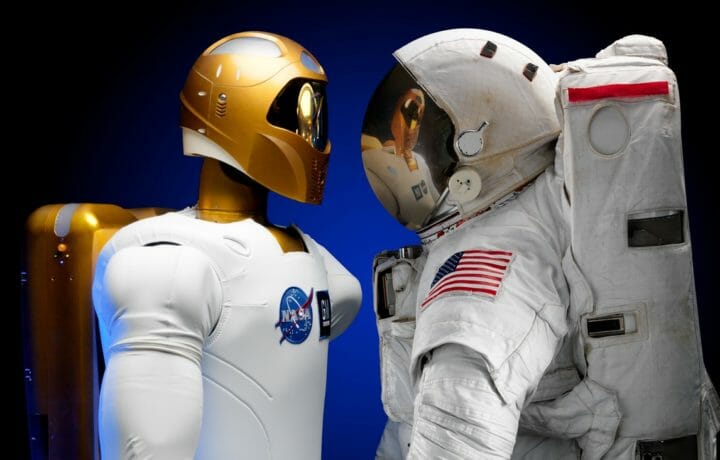 Human spacesuit and robotic astronaut facing each other