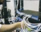 Man plugging cords into back of server rack