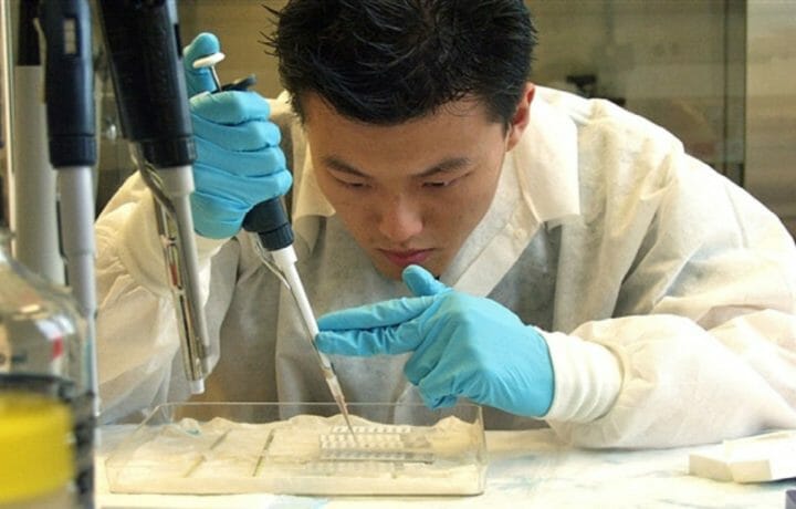 Man delicately filling vials in a lab