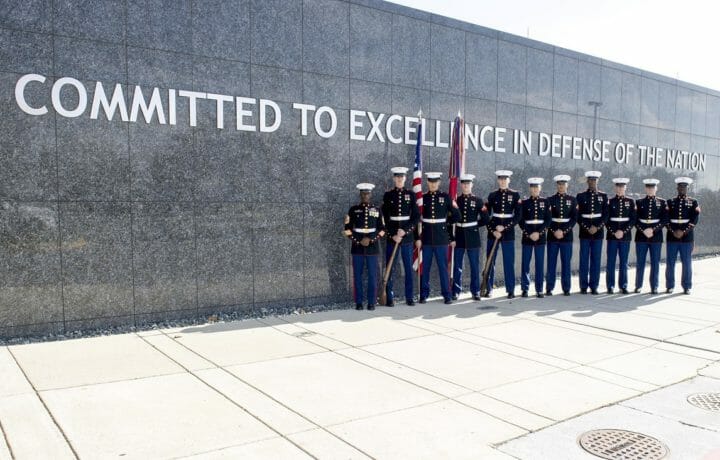 DIA Marines in front of wall with words committed to excellence in defense of the nation