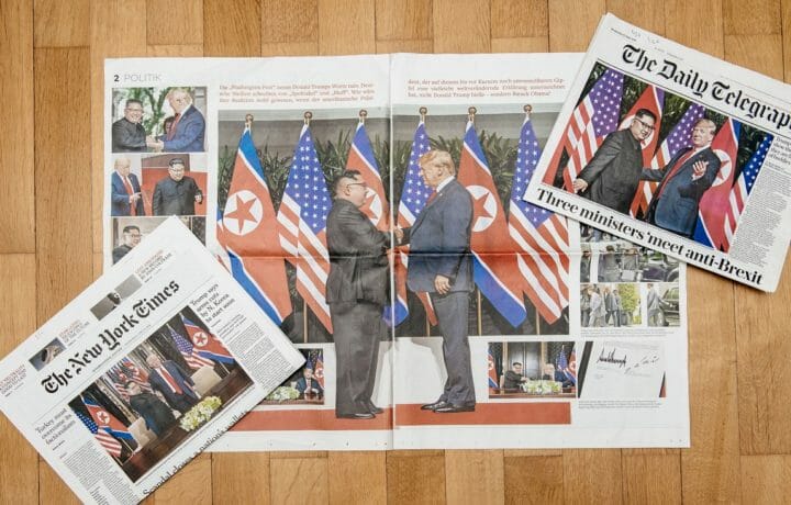 Photo of New York Times and Daily Telegraph newspapers on table showing President Trump and Kim Jong-un meeting