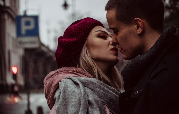 Photo of woman and man kissing on the street