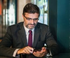 Photo of man in business suit using a phone