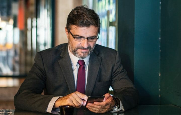 Photo of man in business suit using a phone