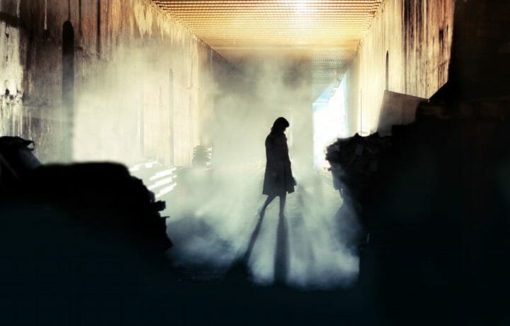 silhouette of female spy in the shadows with fog mysterious
