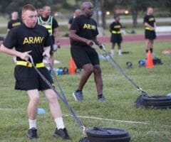 ACFT two men dragging weights in field
