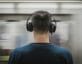 Man wearing headphones with passing subway train