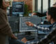 Software developers discussing about source code compiling discovers errors and asks the rest of the team for explanations in front of multiple screens running algorithms. Programmers doing teamwork.