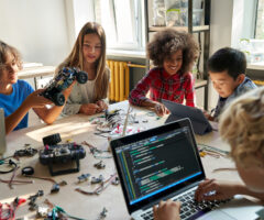 Diverse School Children Students Build Robotic Cars Using Computers and Coding.