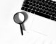 magnifying glass with keyboard laptop