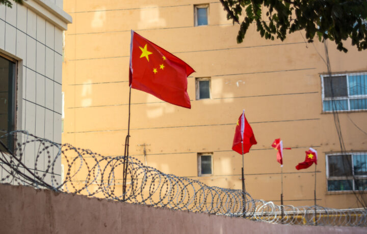 Chinese flags on barbed wire wall in Kashgar (Kashi), Xinjiang, China.