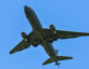 Photo of the underside of the Air Force's KC-46A Pegasus flying. The sky is a clear and bright blue.
