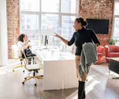 woman waving goodbye to colleague in the office