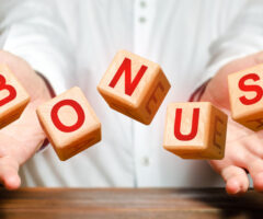 Photo of a person holding their hands out with blocks spelling out "BONUS"
