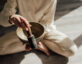 Photo of a person sitting cross-legged with a singing bowl